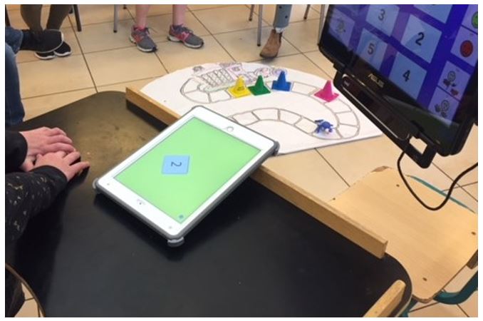 תלמידה משתמשת בIssieDice להטלת קוביה בזמן משחק עם חברי הכיתה